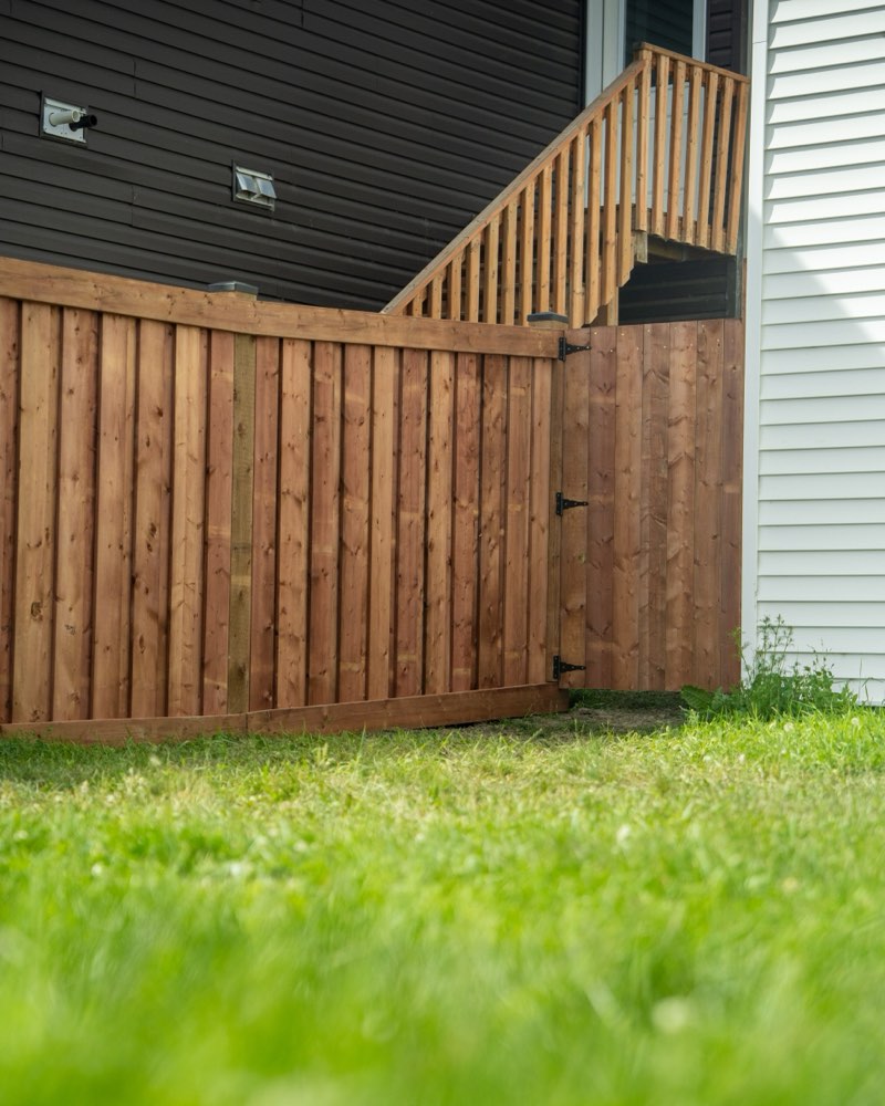 Cedar privacy fence and matching gate beside a house